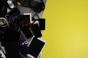 A pile of old electronics on a yellow background.