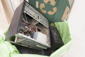 Recycling bin full of old electronic devices in office building